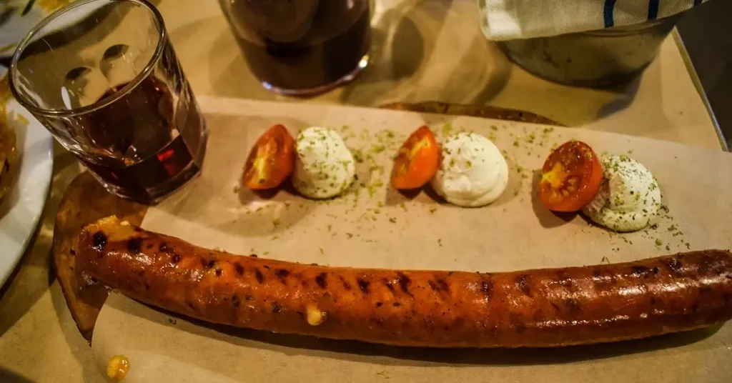 Sausage stuffed with feta cheese and a glass of red wine served in Aranto restaurant.