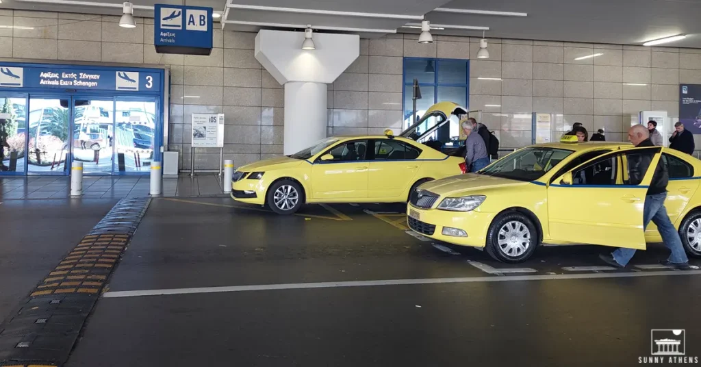 Driver and passengers boarding yellow taxis outside Gate 3 of the Athens International Airport.