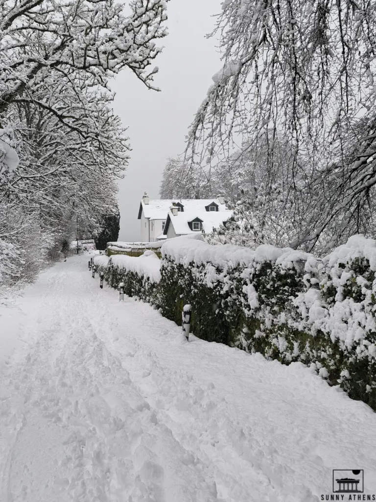 4 days in Edinburgh itinerary: a snow-covered path leading to a white house with trees.