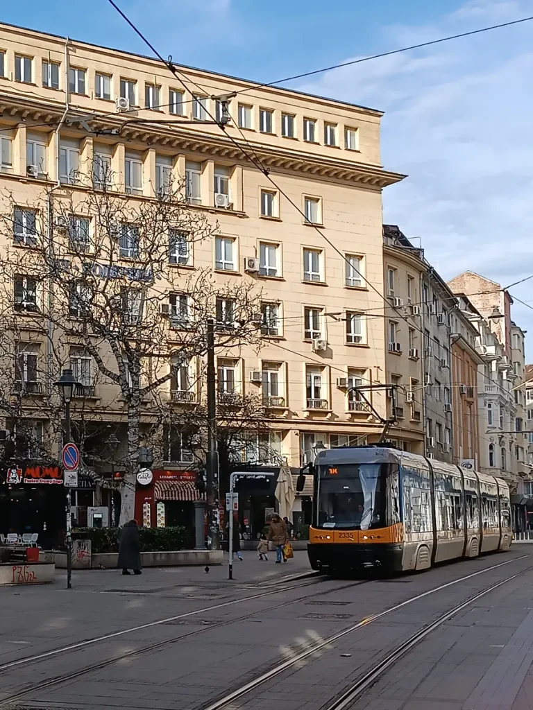 A tram navigating through the streets of Sofia's city center.