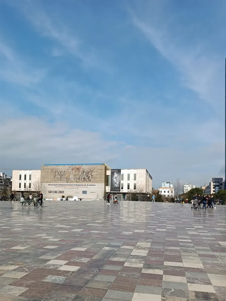 Panoramic view of Skanderbeg Square, with people walking around. A key highlight for any 2 days itinerary in Tirana.