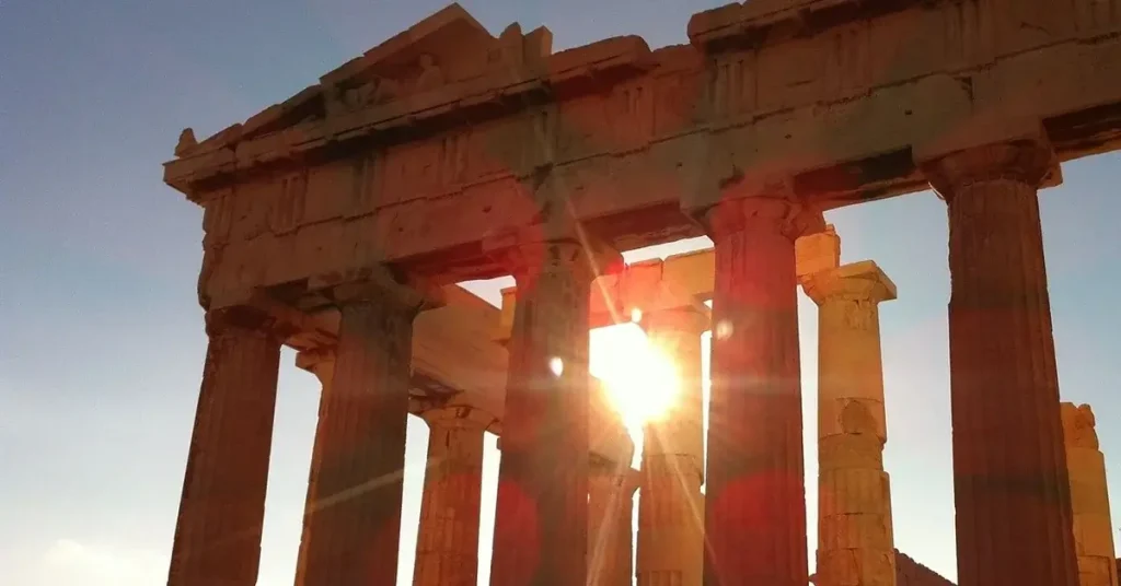 Acropolis myths and legends: Sunrise at the Parthenon with light streaming through the columns.