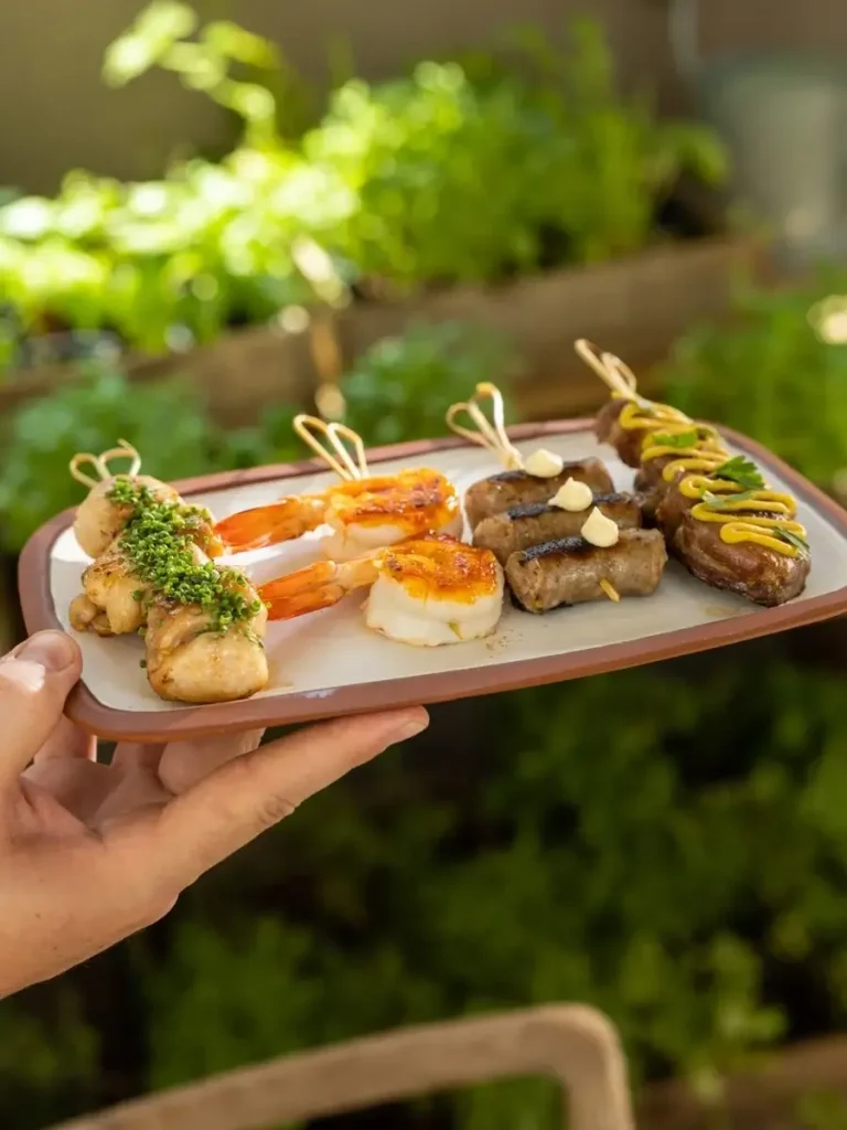 A meze plate featuring local Greek food such as shrimps, small sausages, and souvlaki at Zohos restaurant.