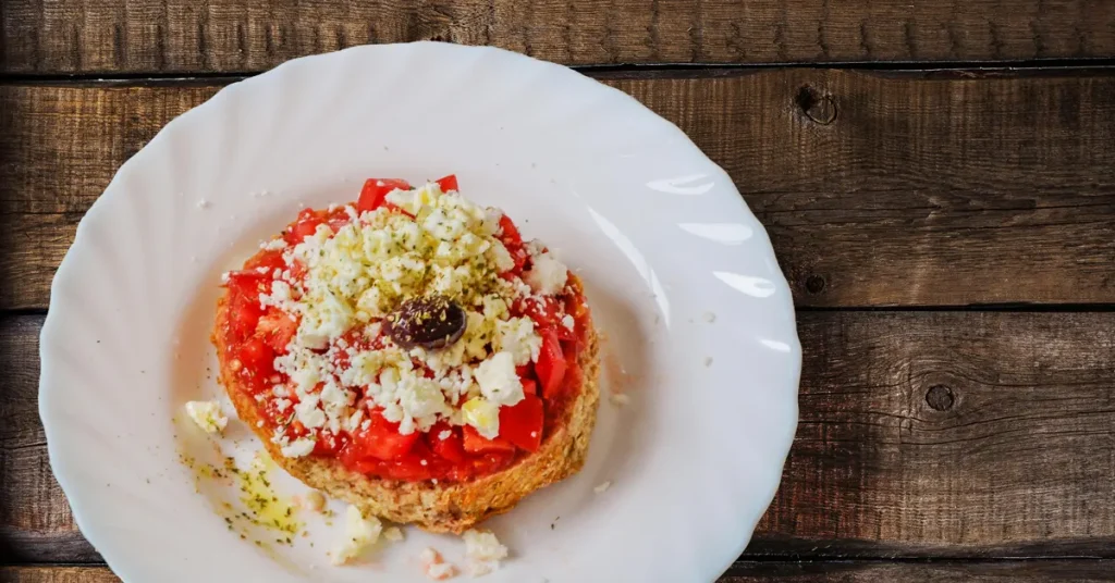 A delicious Dakos, topped with tomato, feta, and olives, an excellent example of traditional Greek cuisine.