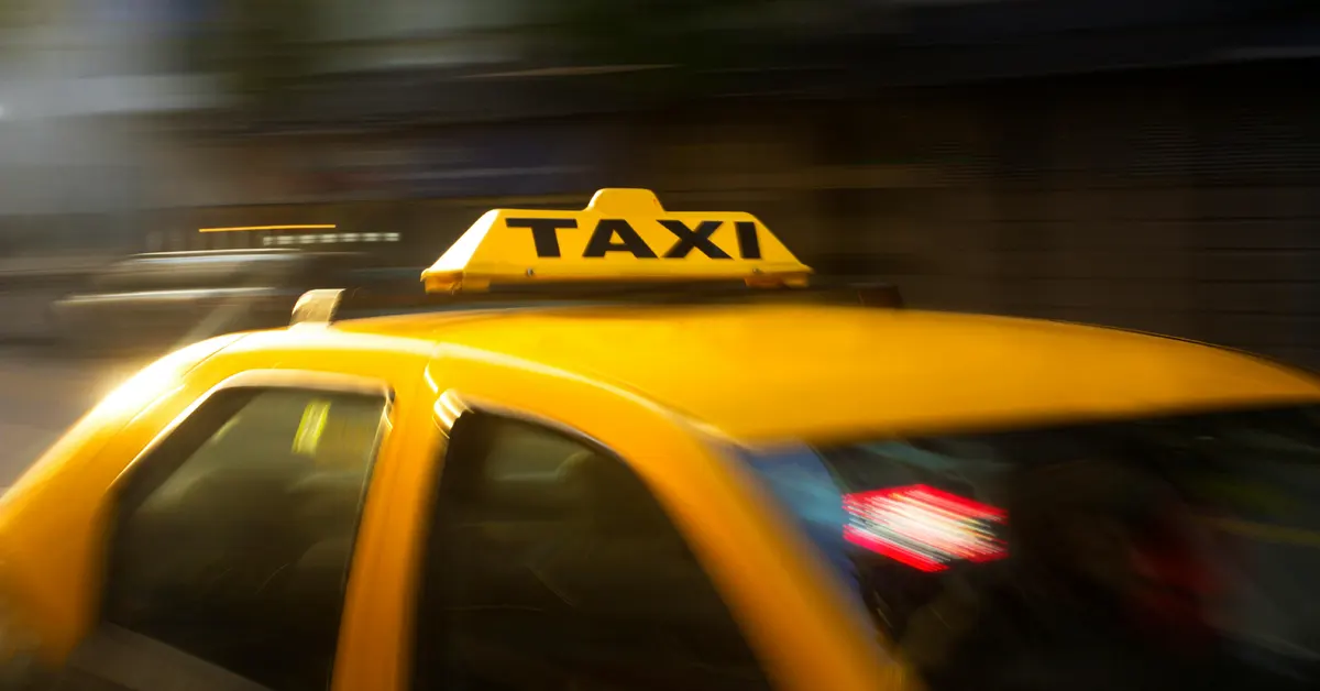 A moving yellow taxi with a "TAXI" sign on top.