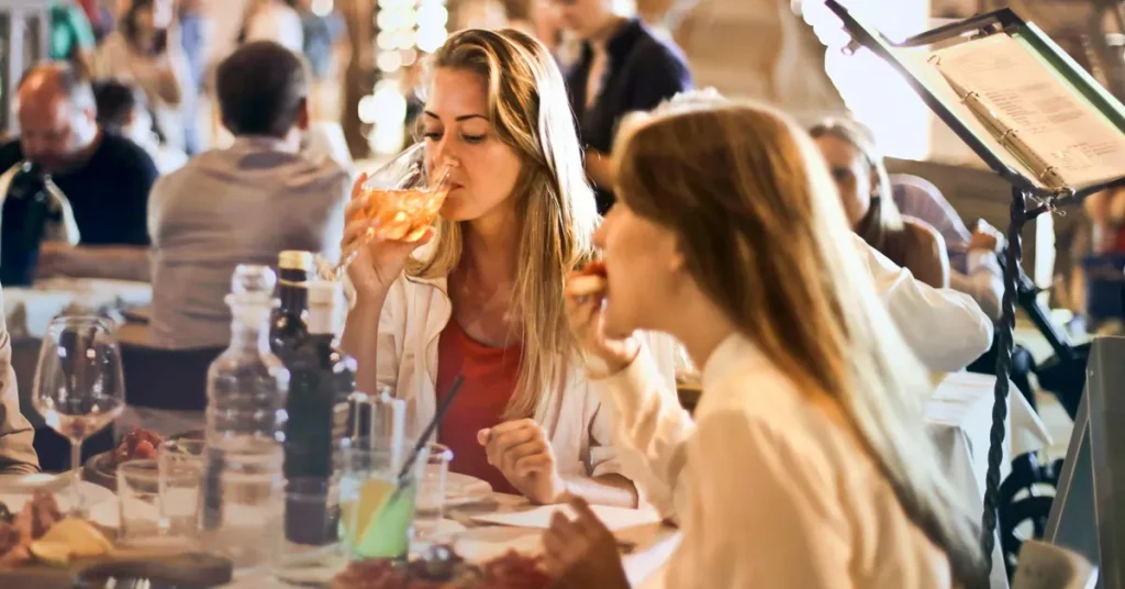 A group of friends drinking wine at a stylish restaurant in Athens, a common delight on food tours for foodies.