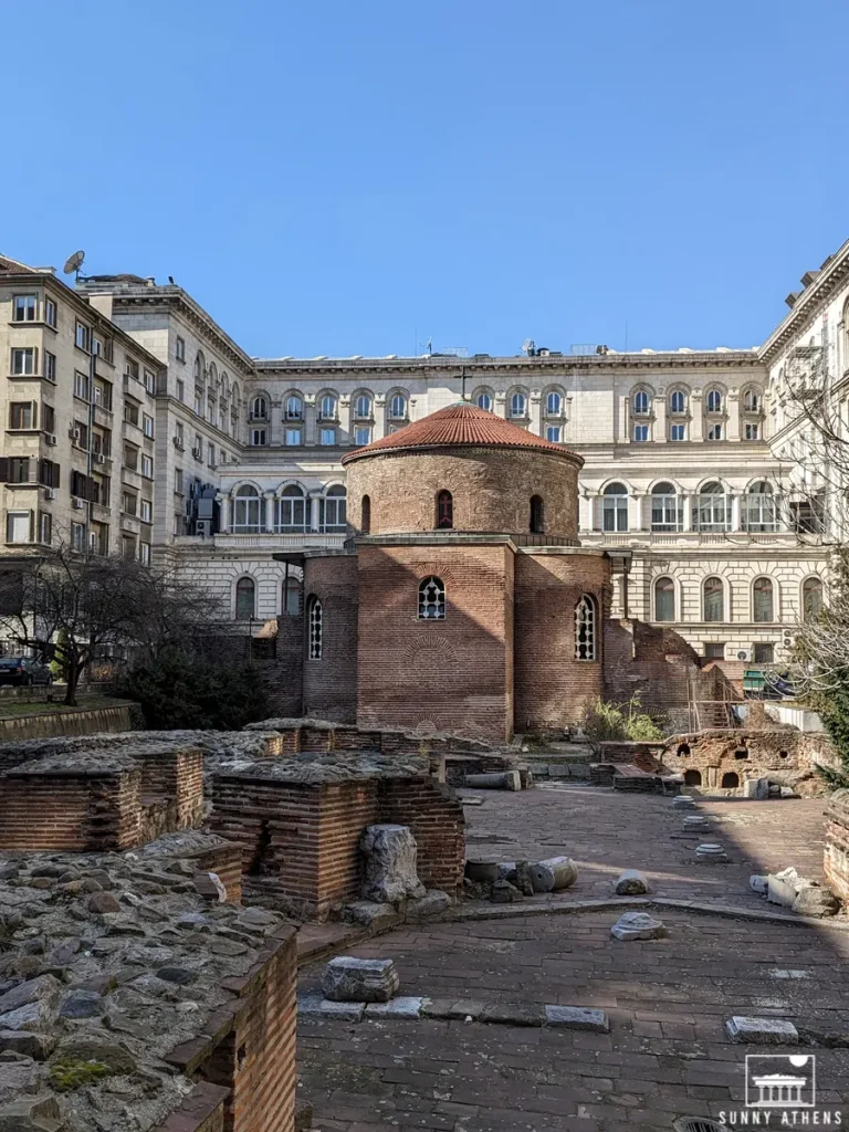 Exterior view of the Saint George Rotunda Church surrounded by buildings, a must stop in your 2 days in Sofia.