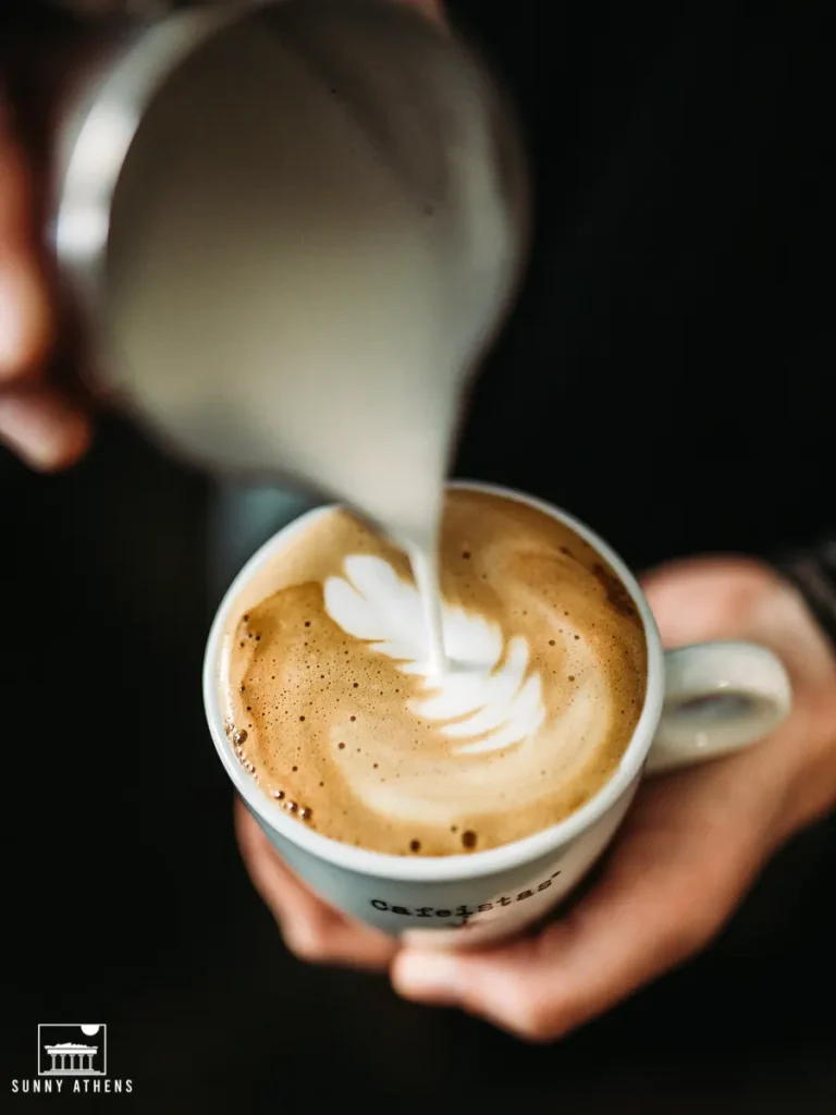 Pouring steamed milk into a flat white drink.