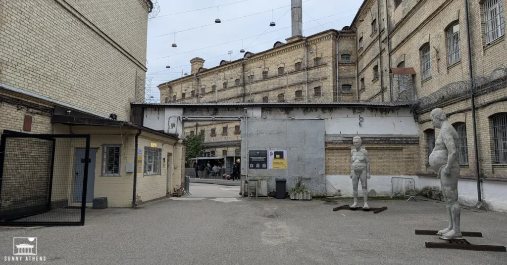 3 days itinerary of Vilnius: The entrance of Lukiškės Prison 2.0, now a creative space and cultural hub, with two statues of naked men on the right and a slightly frightening atmosphere.