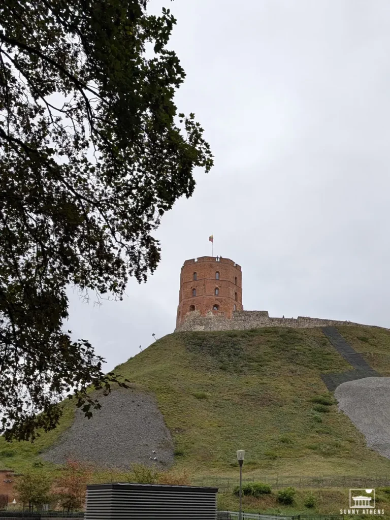 The iconic Gediminas Castle Tower atop a hill in Vilnius, viewed from below.