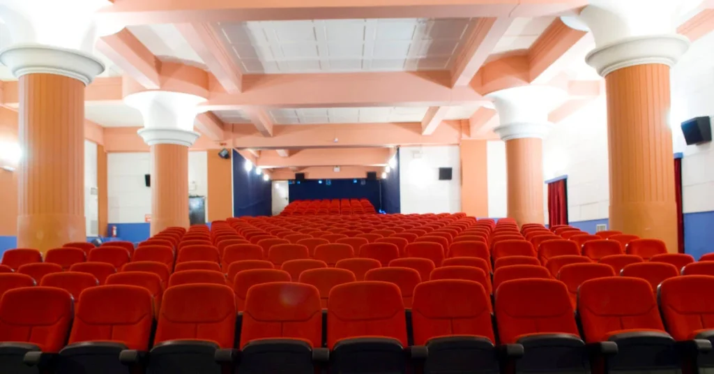 Best indoor cinemas in Athens center: The main screenign room of Asty cinema looking from the screen back at the red seats with four large columns flanking the seating area