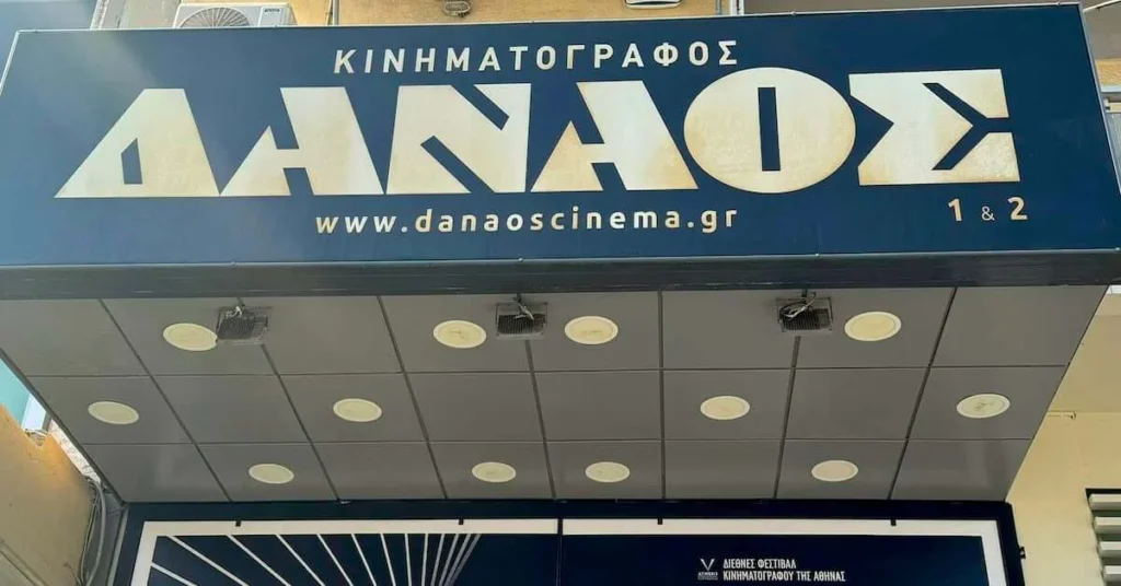 The blue marquee featuring the venue name in white retro lettering of Danaos cinema one of the best indoor cinemas in Athens center