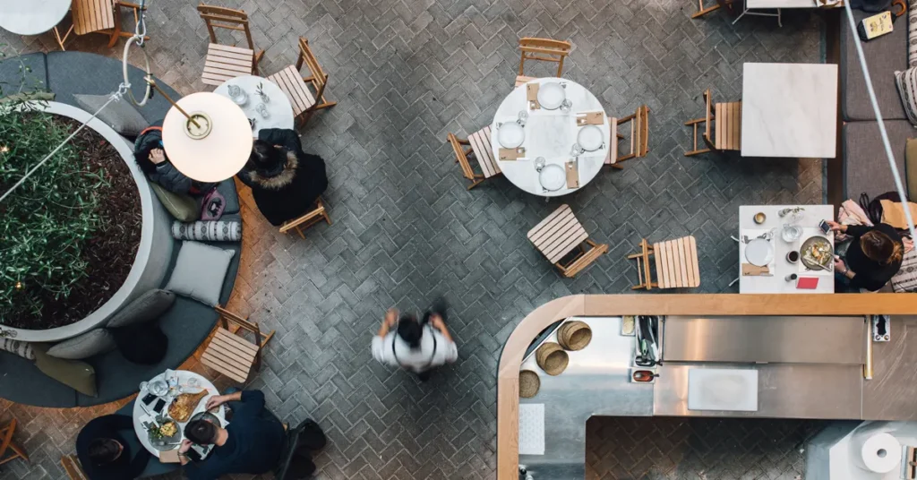 Overhead view of Ergon House restaurant with round and square tables, and wooden chairs.