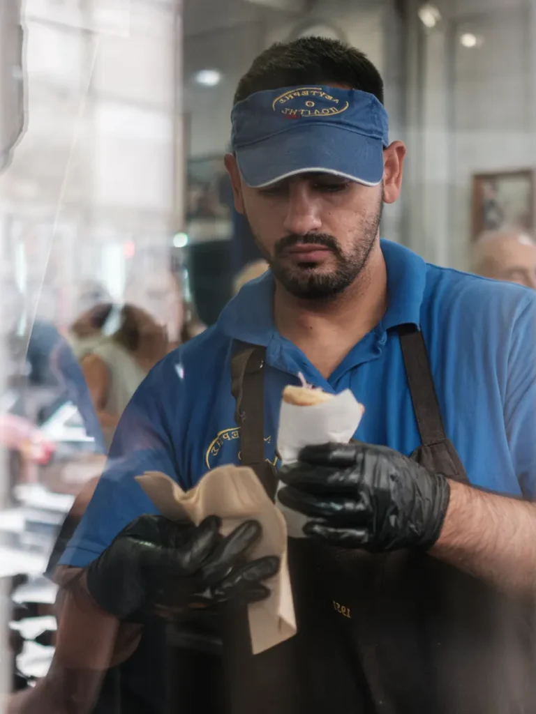 A cook wraps a freshly prepared souvlaki at Lefteris o Politis with focused attention.