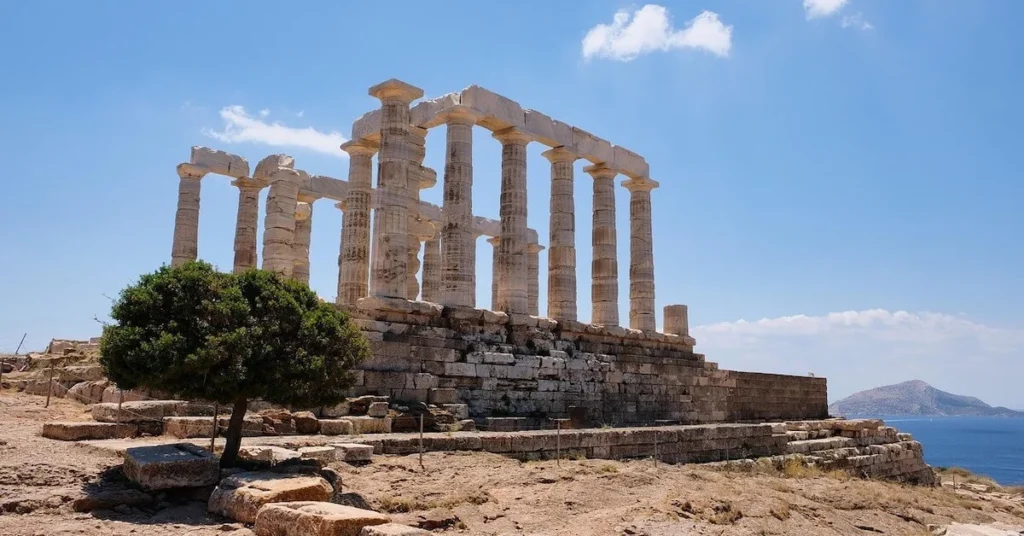 A small tree in front of the Temple of Poseidon in Sounio under the bright sun.