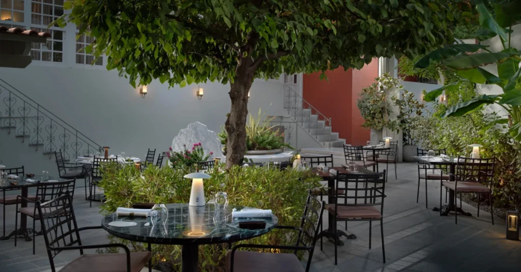 The courtyard of CTC Urban Gastronomy restaurant with lush greenery, romantic lighting, and elegant outdoor seating.