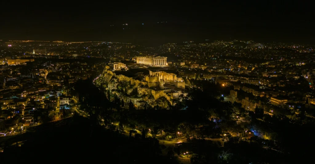 Honeymoon in Athens: aerial night view of the illuminated Acropolis, surrounded by the twinkling lights of Athens.