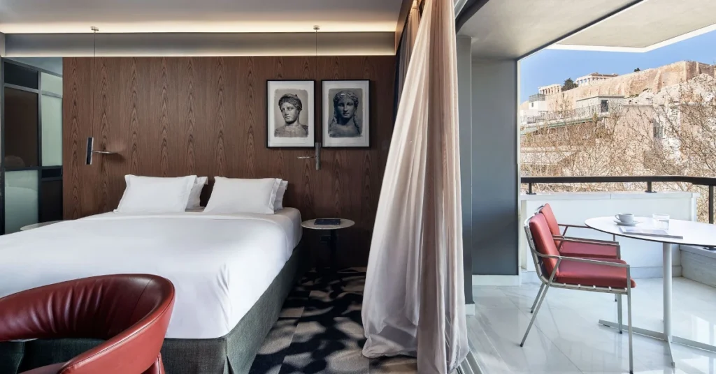 A luxurious room of AthensWas Hotel, with a private balcony overlooking the Acropolis.