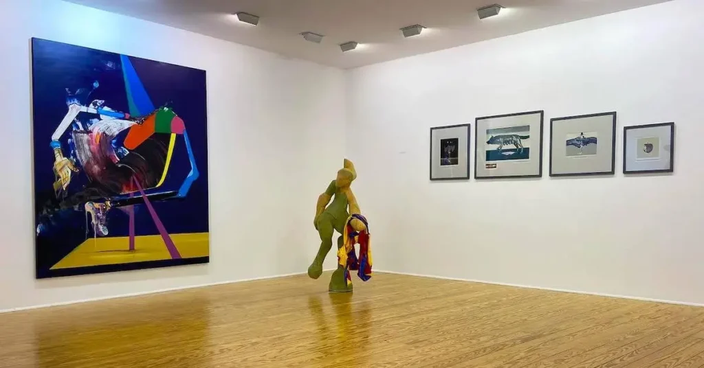 View of the exhibition space of a.antonopoulou.art, one of the places to visit when in Psiri, Athens, with a large painting on the left, a sculpture in the middle and some smaller artworks on the right.