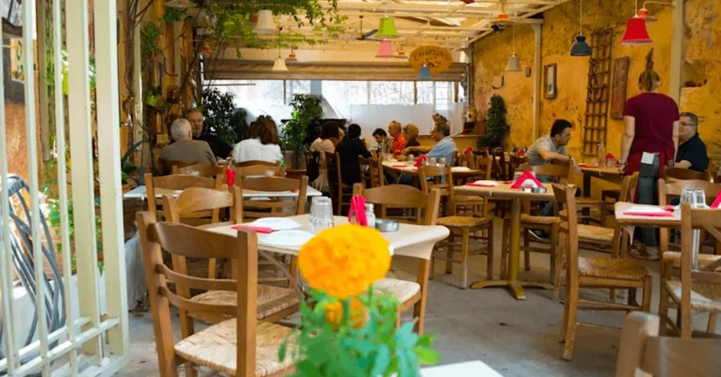 View of the interior yard of Enastron restaurant, with a few patrons eating and talking.