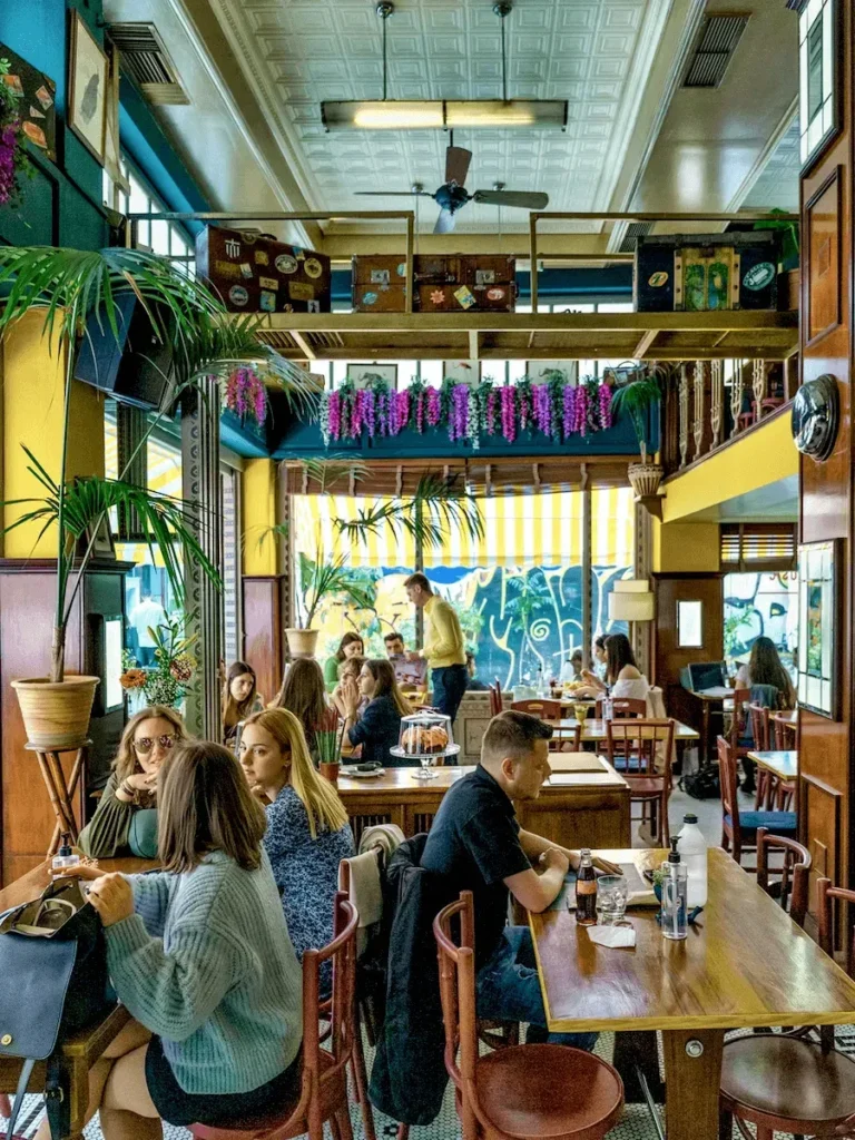 Coloroful daily interior view of the Brunchers brunch restaurant, with a young crowd sitting on the tables.
