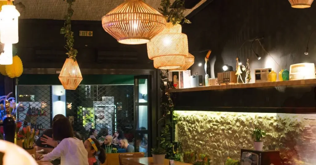 Interior view of Tranzistor cafe-bar in Psiri, Athens, showing the various ceiling lights and a few patrons sitting at the bar.