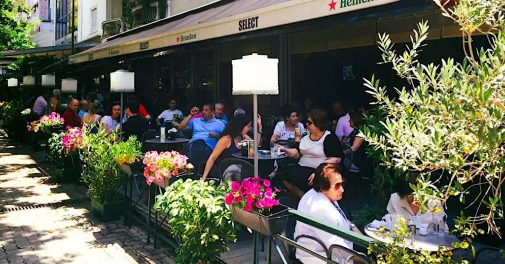 Kypseli Athens Travel Guide: Exterior view of the historic Select cafe in Fokionos Negri with people sitting at the tables enjoying their coffee