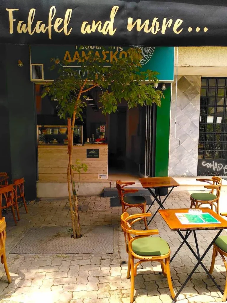 Kypseli Athens Travel Guide: Front view of Syrian restaurant Gefseis Tis Damaskou in Fokionos Negri pedestrian street in Kypseli with a few tables