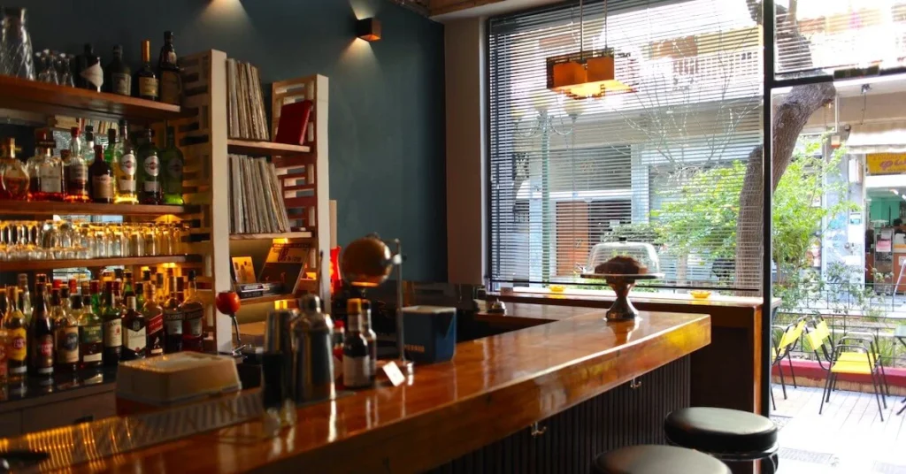 Kypseli Athens Travel Guide: Interior view of Iznogood & Nephew bar looking out at Agiaw Zonis pedestrian street in Kypseli