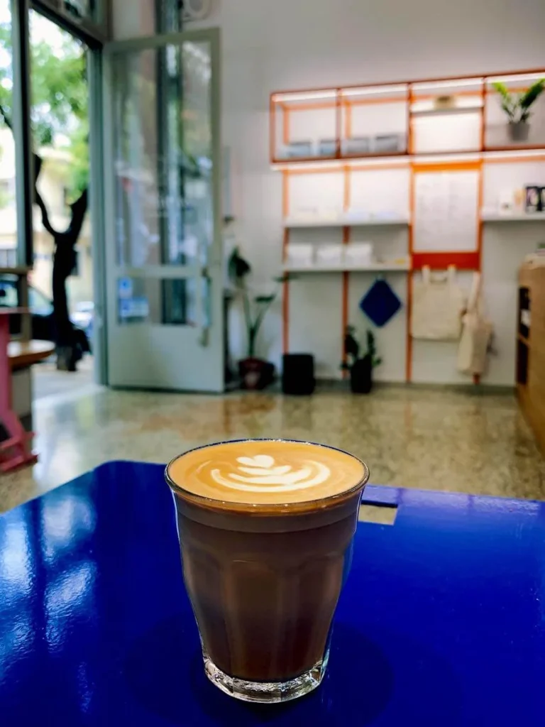 Kypseli Athens Travel Guide: Interior view of Williwaw coffee roasters in Kerkyras street in Kypseli with a nice freddo espresso in the foreground