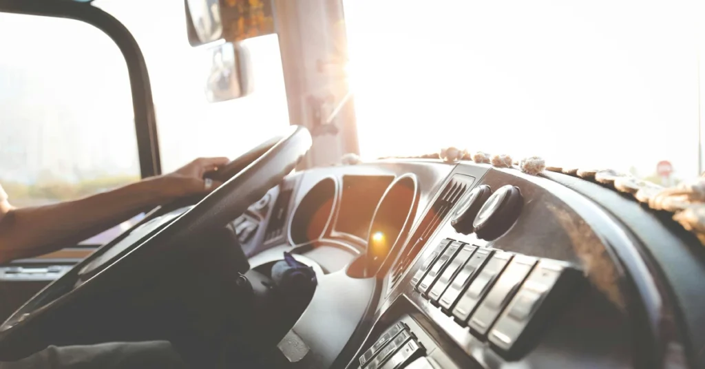 Sun flaring over the dashboard of a driver's seat of a KTEL bus.
