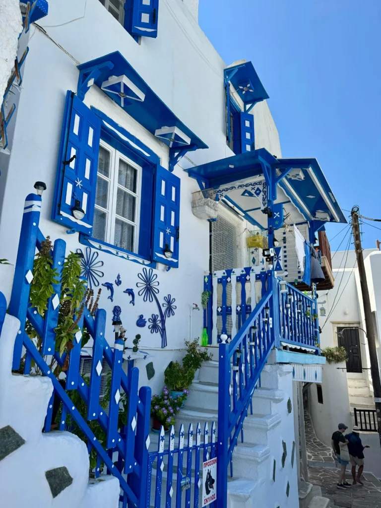 Traditional Cycladic house with blue windows and white walls.