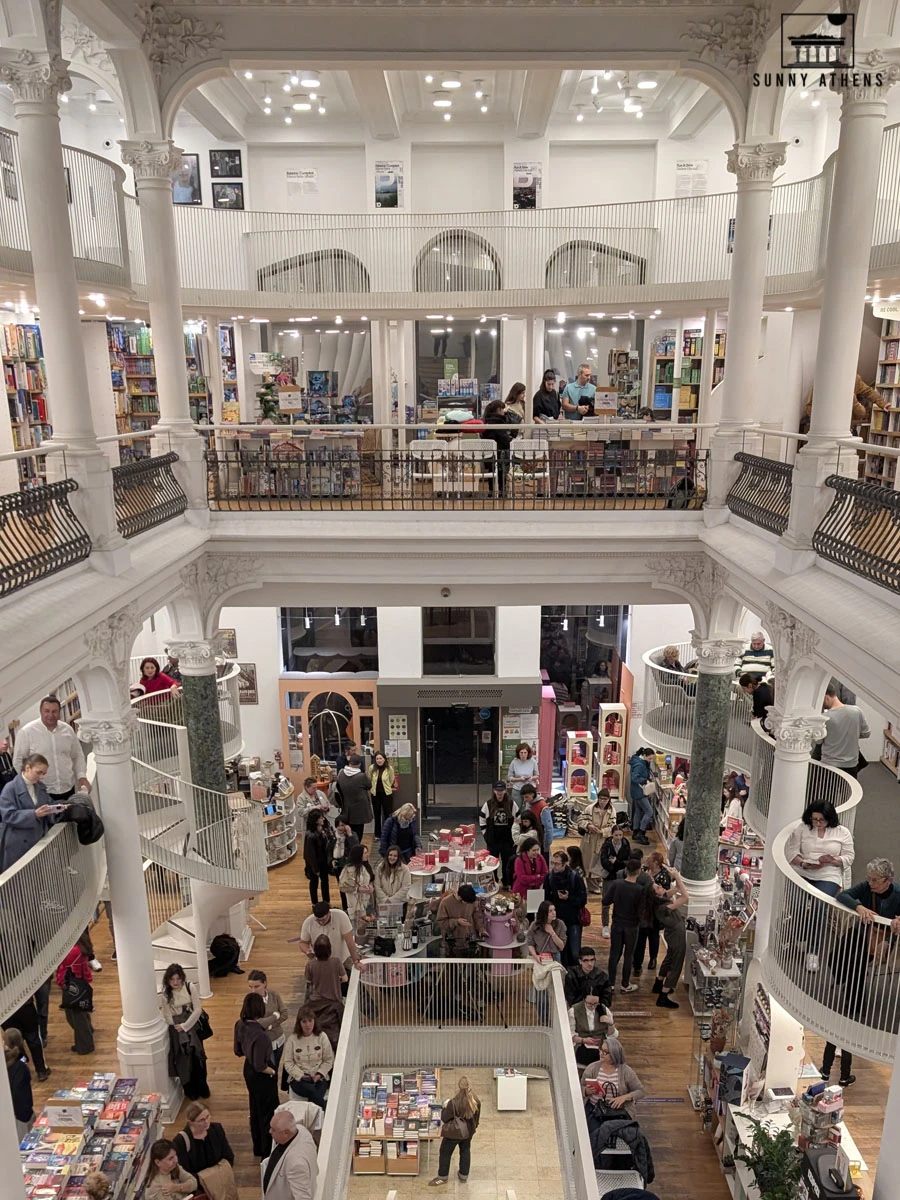 The beautiful, multi-level interior of the Carturesti Carusel bookstore, featuring white columns and spiral staircases.