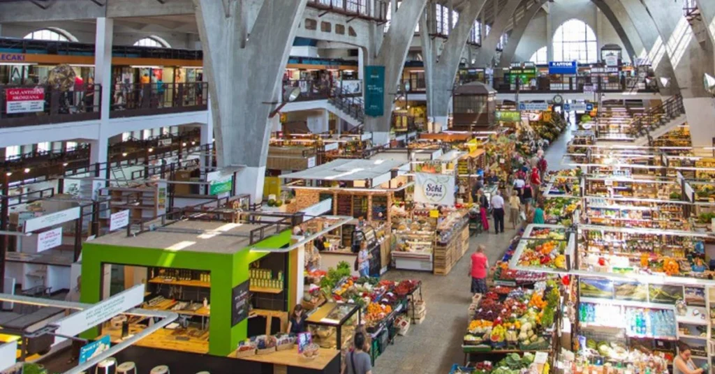 Indoor market stalls filled with fruits, vegetables, and local products at Hala Targowa.