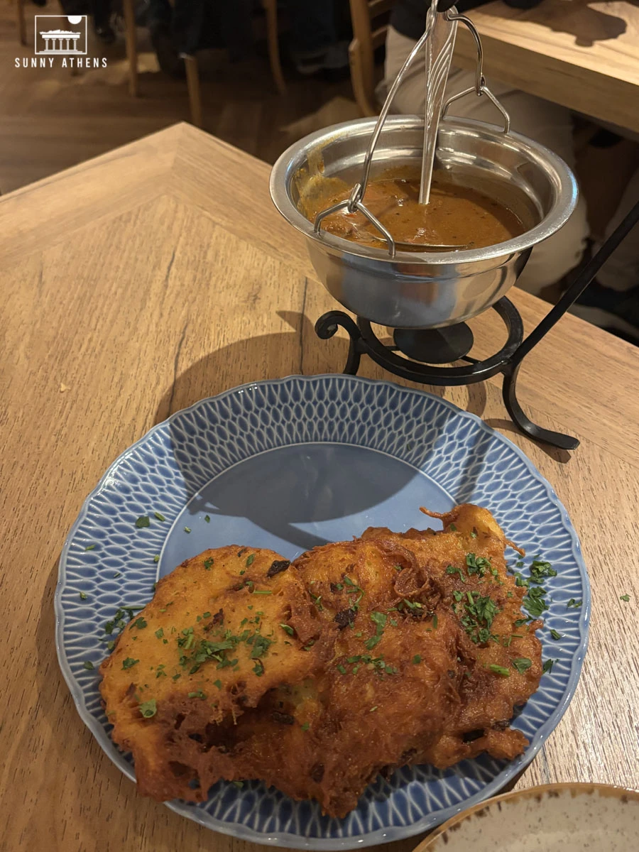 Plate of Polish potato pancakes served with a bowl of goulash at the Czarna Kaczka restaurant.