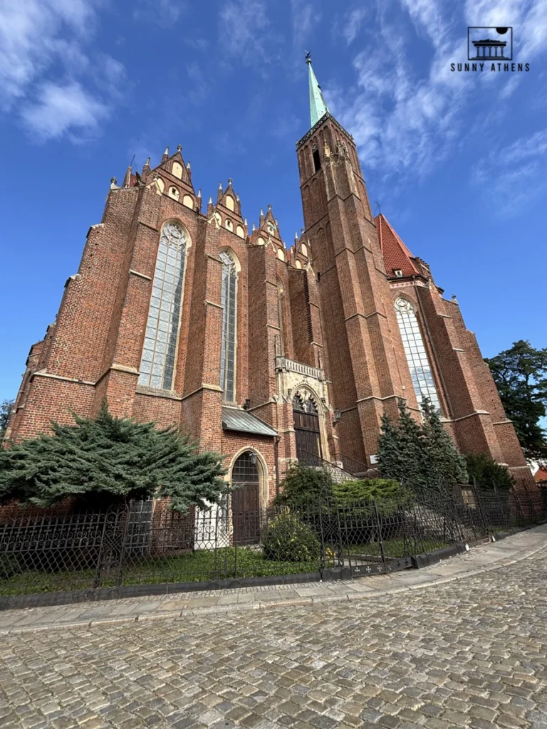 One day in Wroclaw Itinerary: gothic brick Cathedral of St. John the Baptist with a tall green spire.