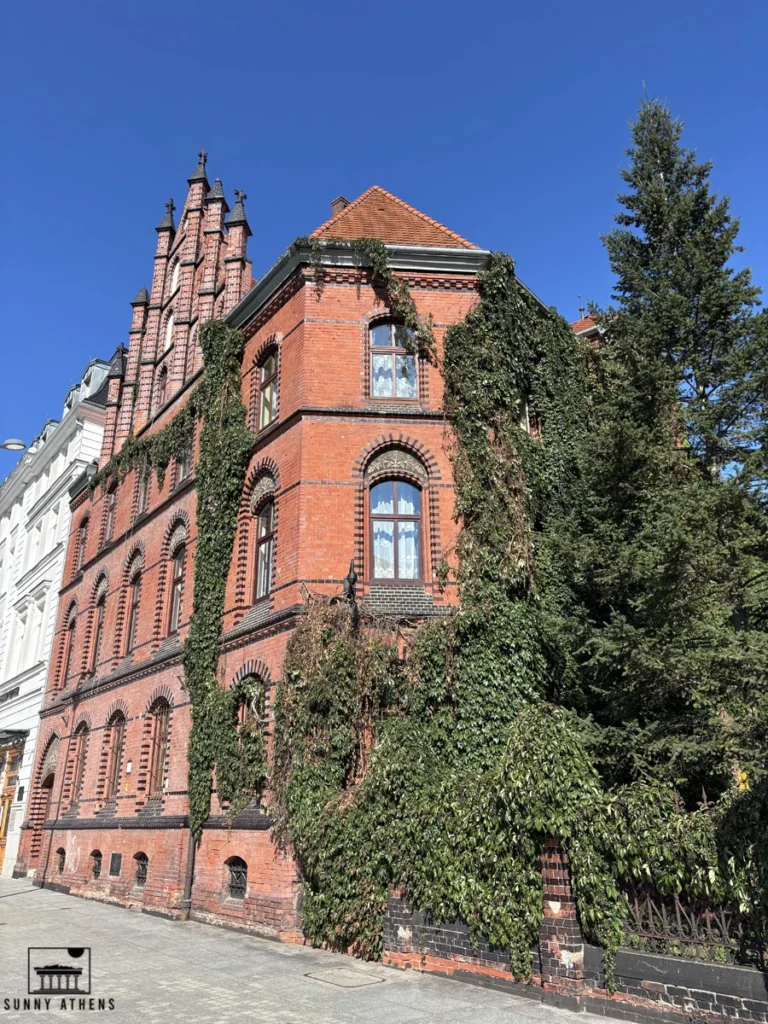 One day in Wroclaw Itinerary: red-brick building with ivy-covered walls and decorative gables in Wroclaw’s Old Town.