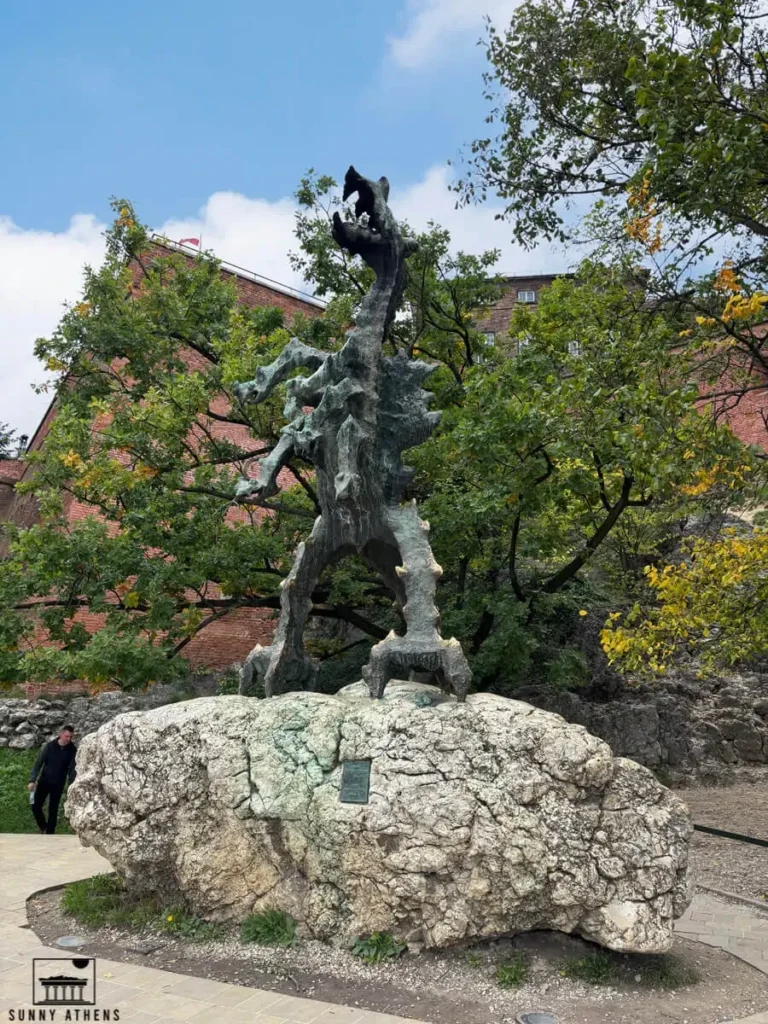 The bronze statue of the Wawel Dragon (Smok Wawelski) on a rock base.