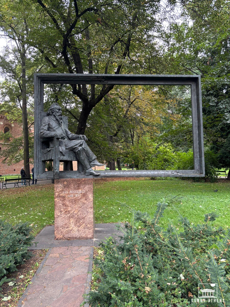 Krakow in 3 days: Bronze statue of the painter Jan Matejko seated in a large metal frame in Planty.