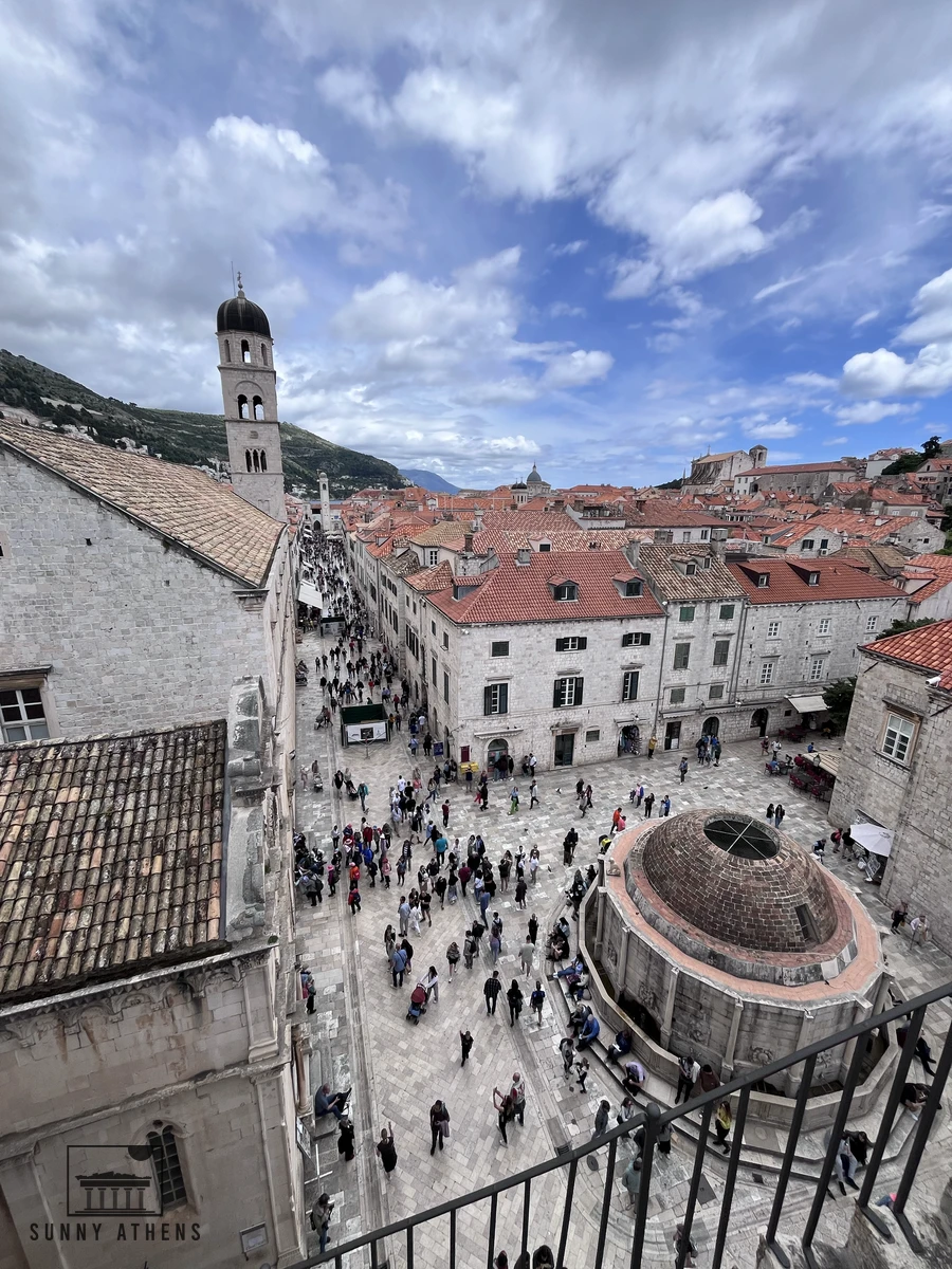 High-angle view from the City Walls looking down onto the carved polygonal stone dome of Large Onofrio's Fountain in the square