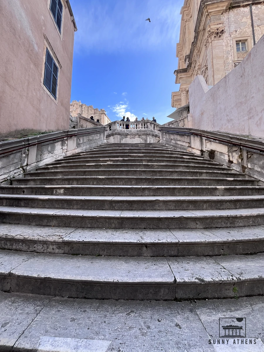 Looking up the curved stone steps of the baroque Jesuit Stairs toward the facade of the Church of St. Ignatius