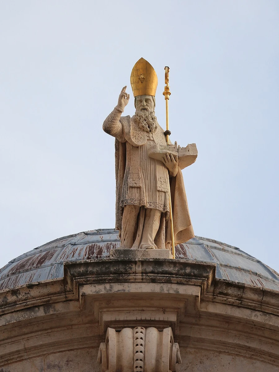 Statue of Saint Blaise atop the church pediment holding a scale model of pre-earthquake Dubrovnik