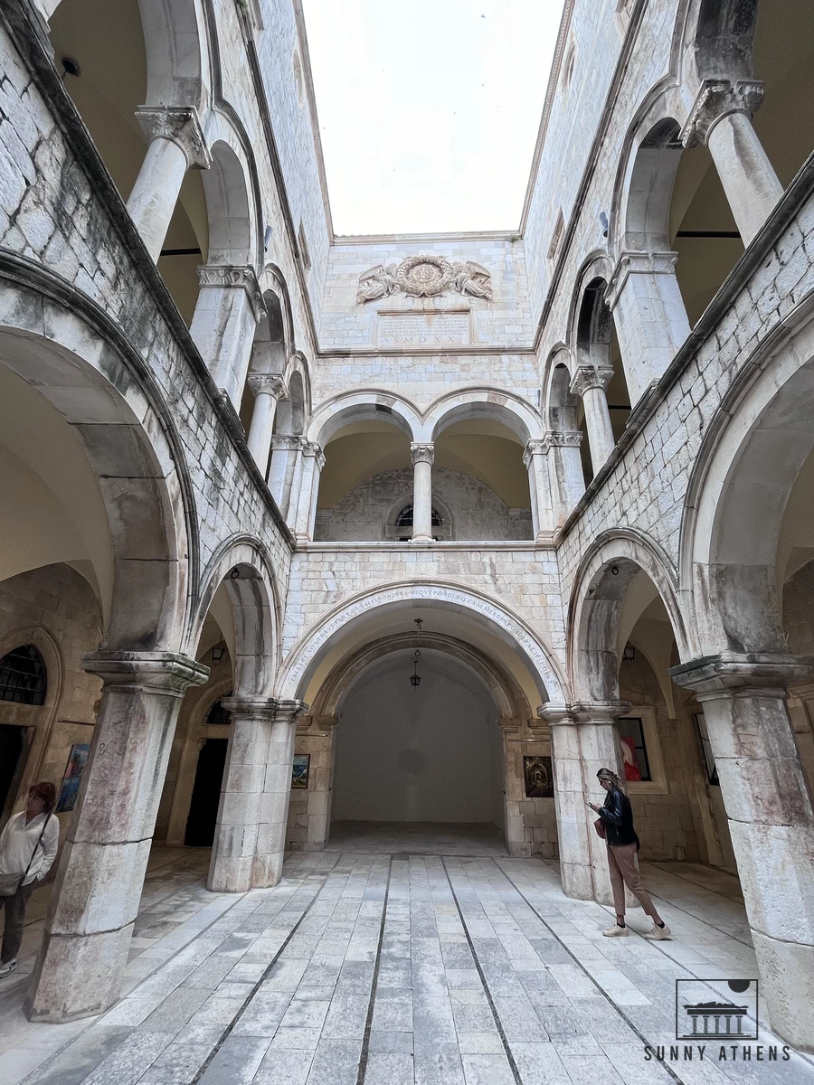 Two-story stone arcades, columns, and Renaissance arches inside the peaceful atrium courtyard of Sponza Palace