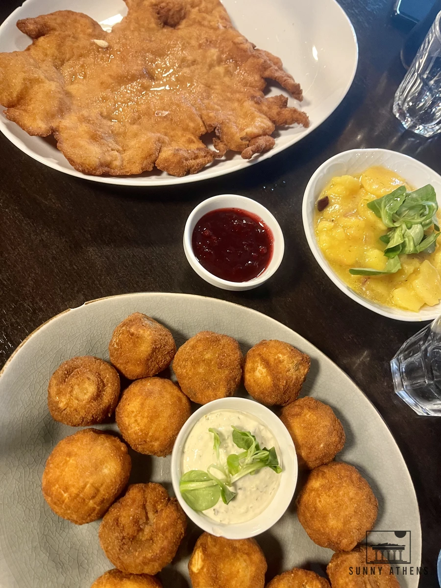 A large breaded Wiener Schnitzel served with lemon and potato salad at Schnitzel One in Vienna