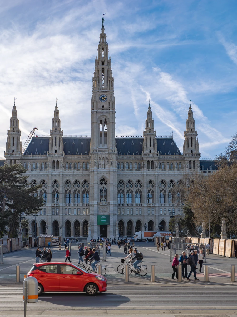 The tall neo-Gothic central tower and facade of Vienna City Hall viewed from the street