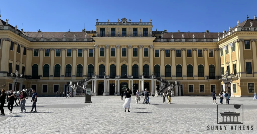 Traveler walking across the grand Ehrenhof courtyard towards Schönbrunn Palace in Vienna