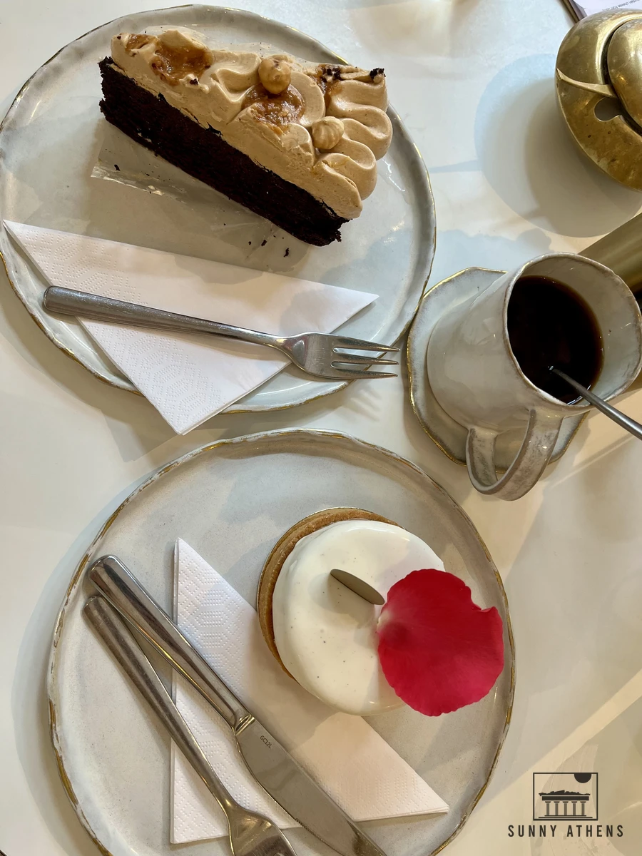 Pastries, eclairs, and coffees served on a marble table at Creme de la Creme in Vienna