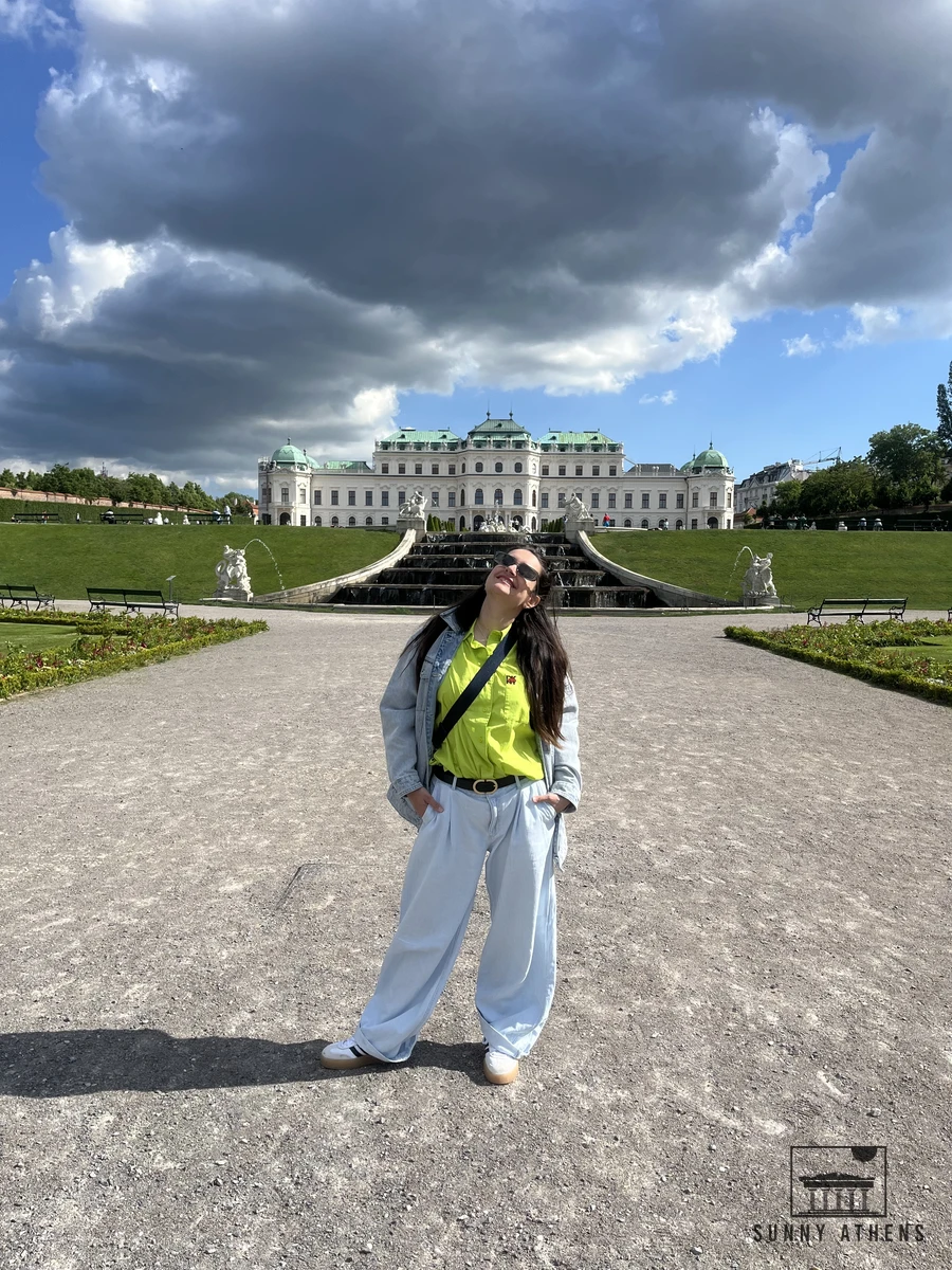 A visitor walking along the gravel path toward the Upper Belvedere Palace in Vienna