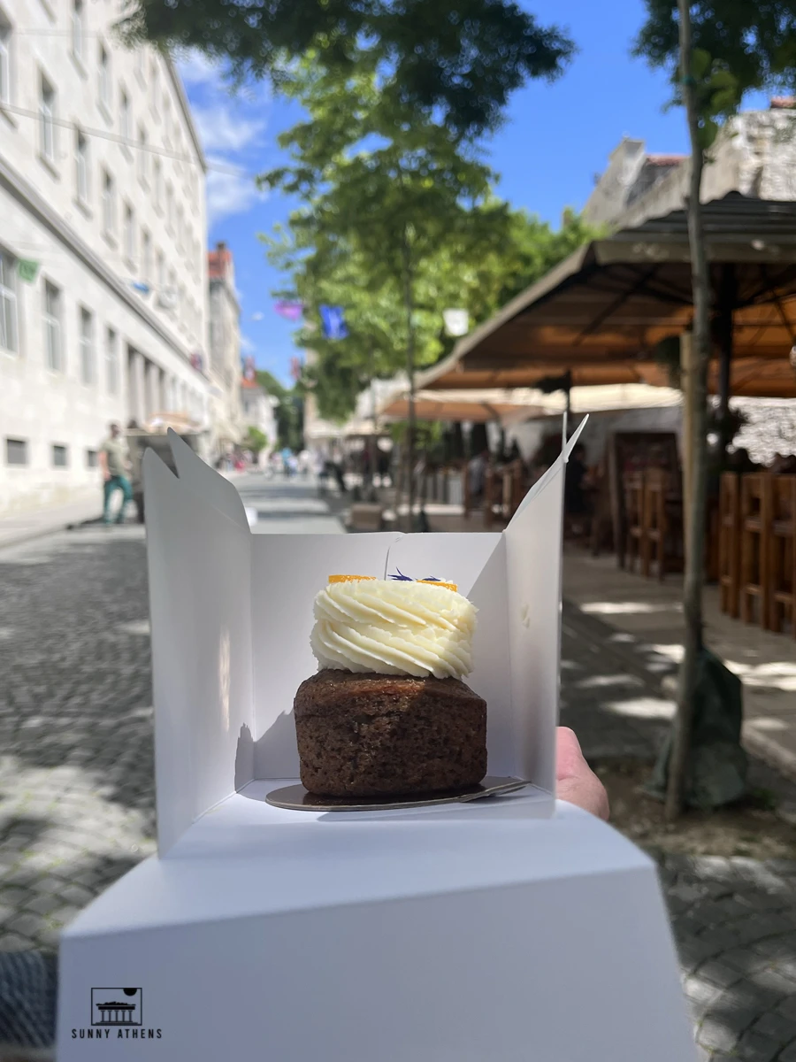 Individual spiced carrot cake with swirl cream frosting in a takeaway box from Os Kolac pastry shop