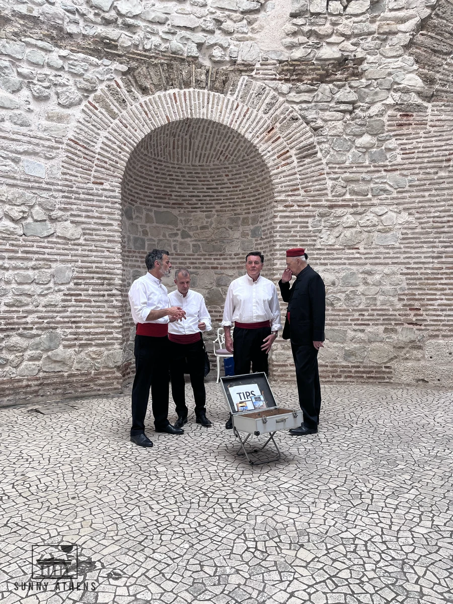 Traditional Klapa vocal ensemble singing in white shirts and red sashes inside the brick rotunda of the Vestibule in Split
